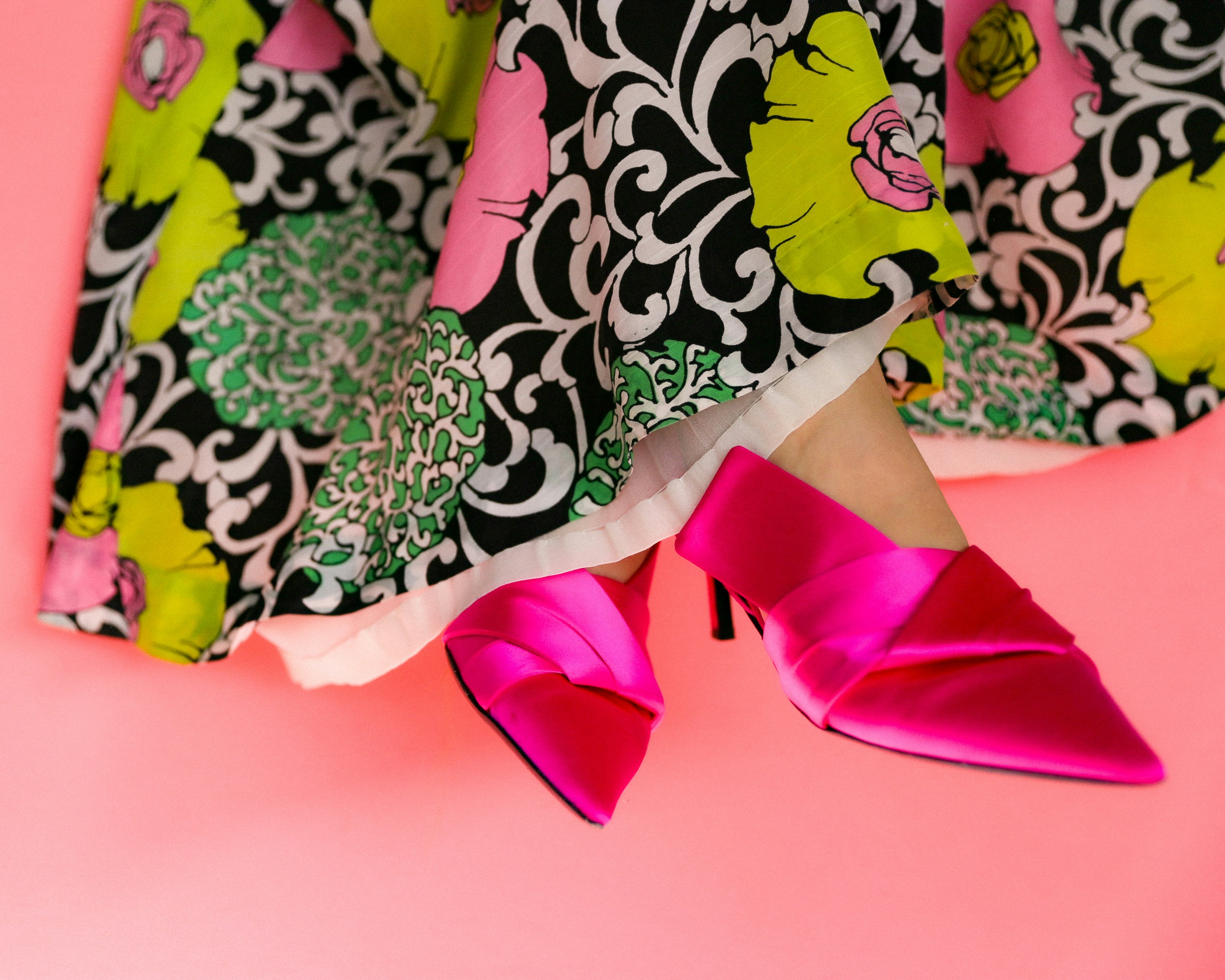 person in pink pants standing on white and green floral textile